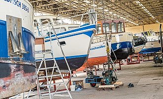 Viele Hausboote stehen in der Werft hintereinander. 