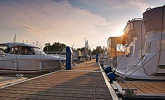 Ein Steg mit Hausbooten im Sonnenuntergang