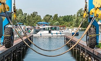 Ein Blick auf die Marina Müritz mit Hausbooten. Im Vordergrund sieht man die Gurte des Krans. 